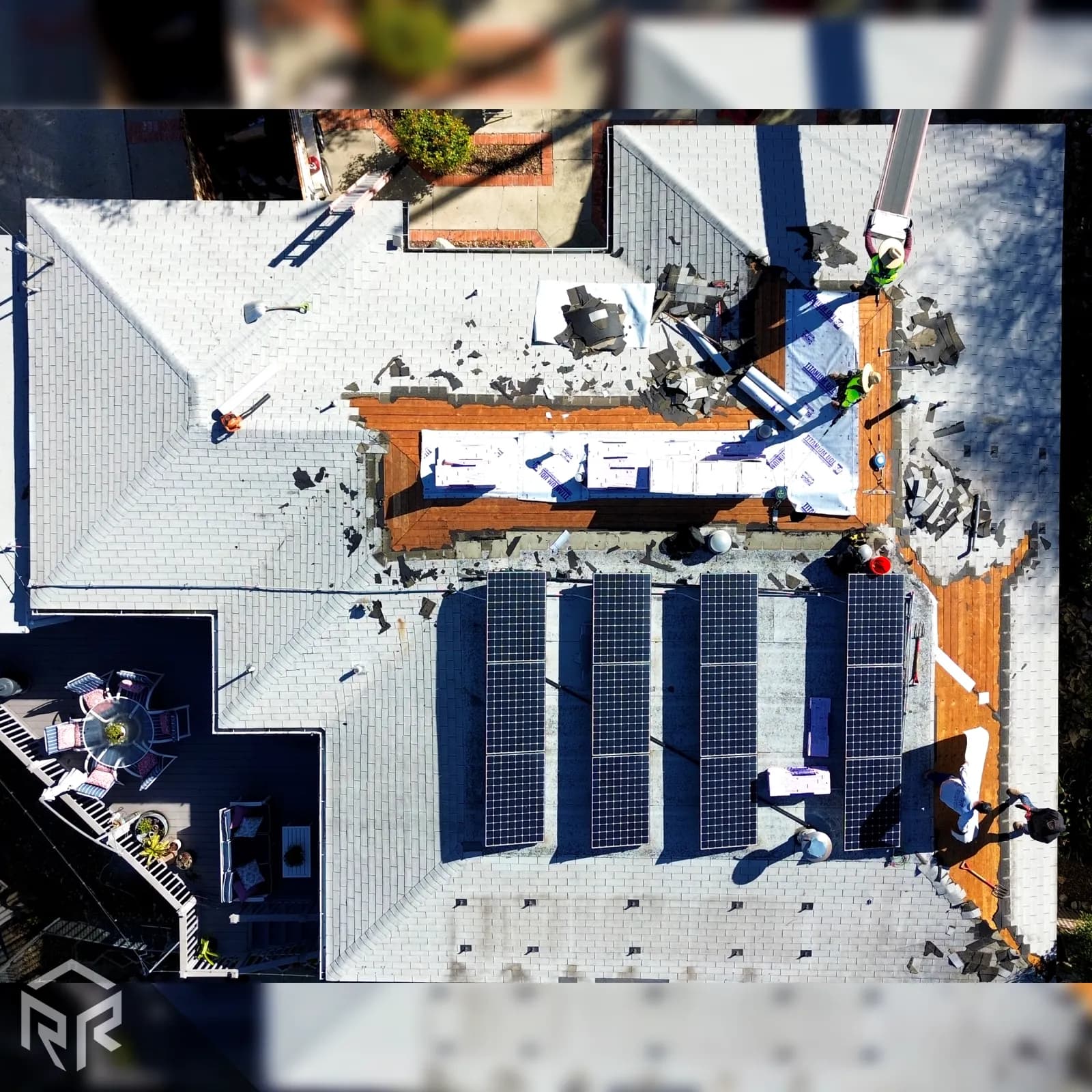 An aerial photo of our tear-off crew working to remove old roofing materials from a shingle roof in San Diego