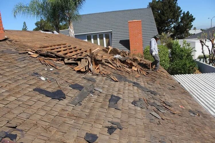 A San Diego roof being torn off down to the deck so the wood structure underneath can be inspected.