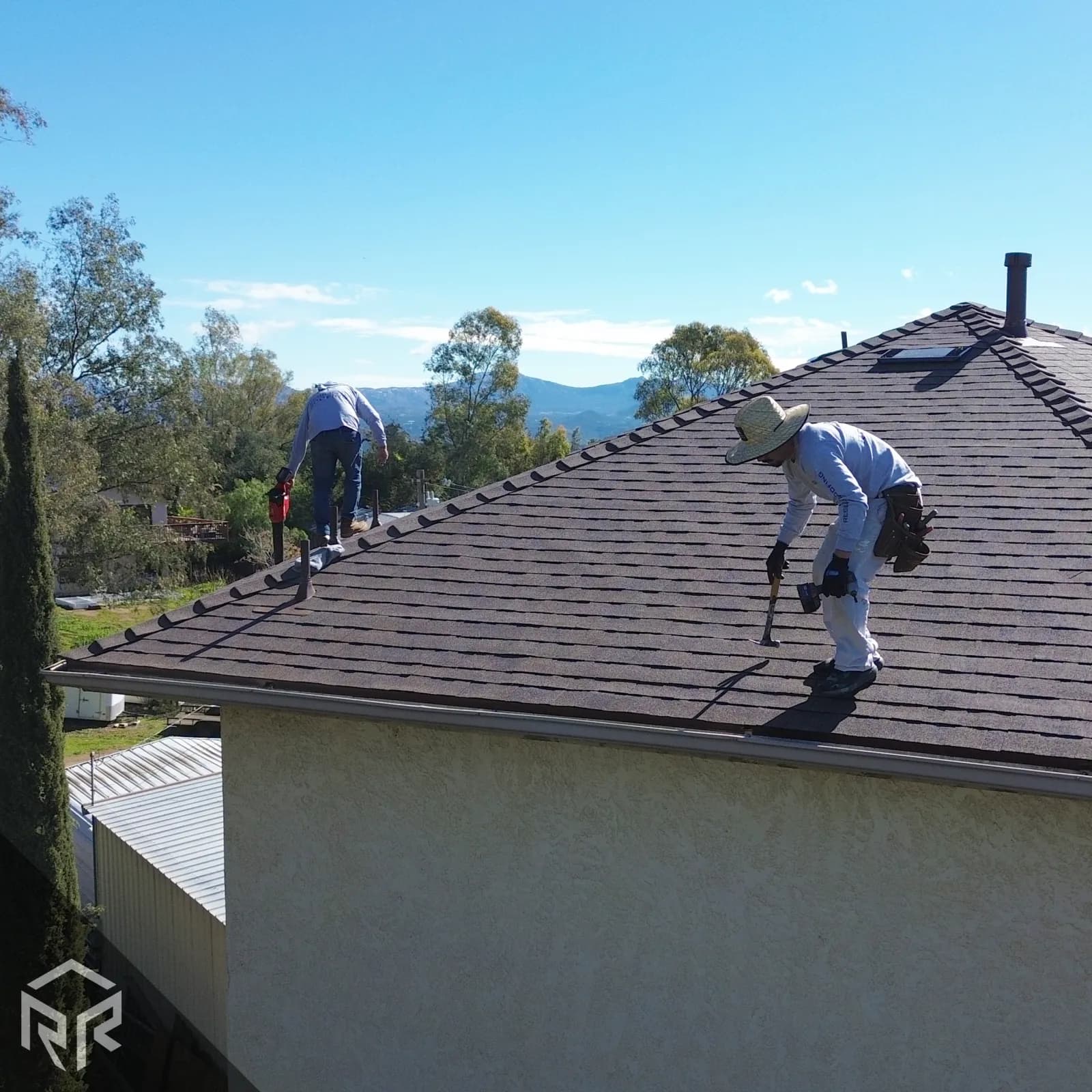 Photo of a Resilient Roofing install crew putting the final touches on a new shingle roof.