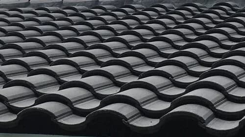 Close-up of a black S-shaped barrel concrete tile roof.