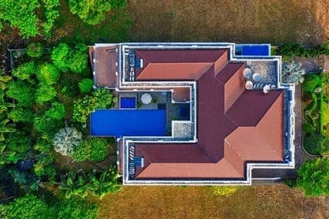 An aerial view of a San Diego home with a red tile roof and a backyard pool.