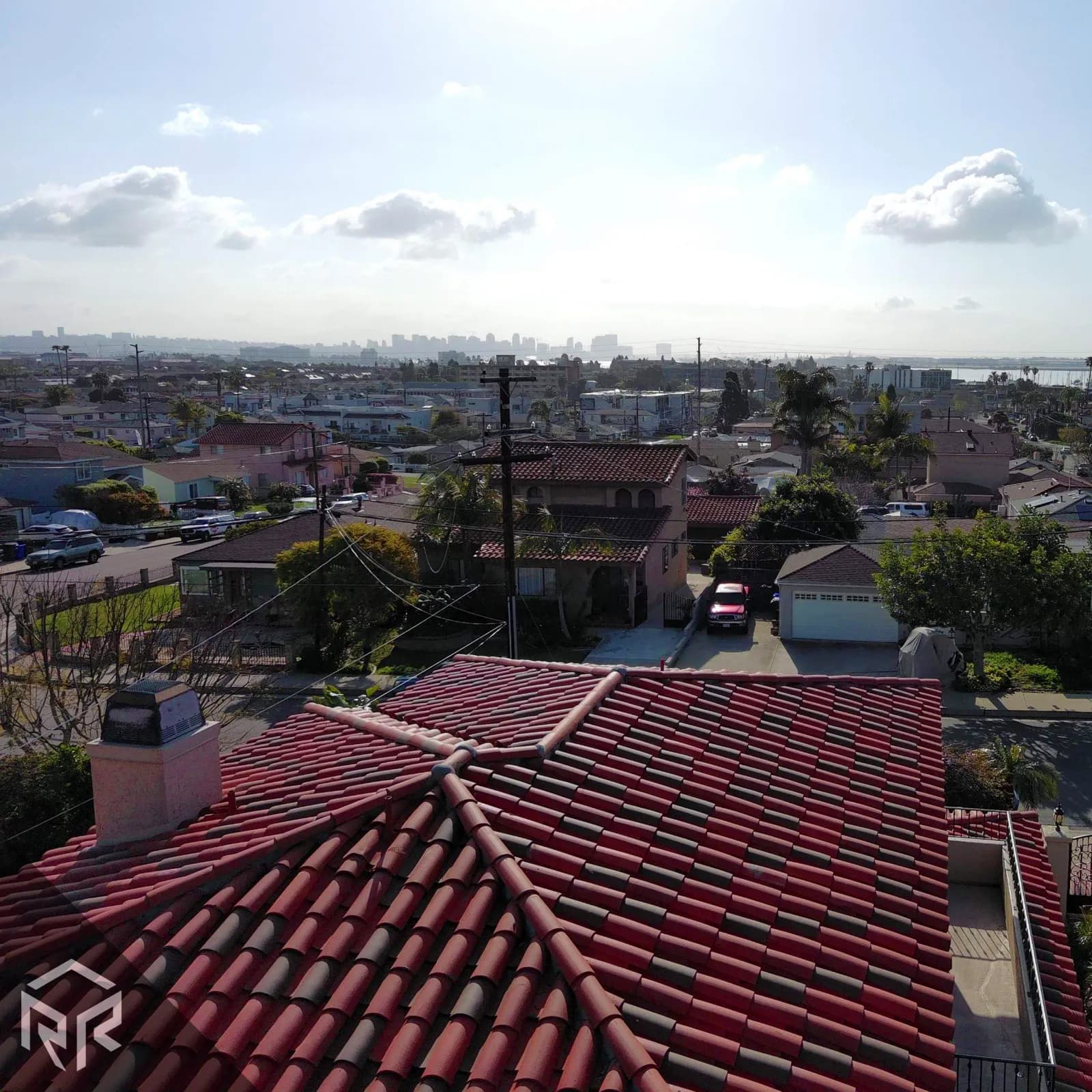 A tile roof with a view of downtown San Diego in the distance.