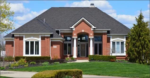 A large brick San Diego home with a dark asphalt shingle hip roof.