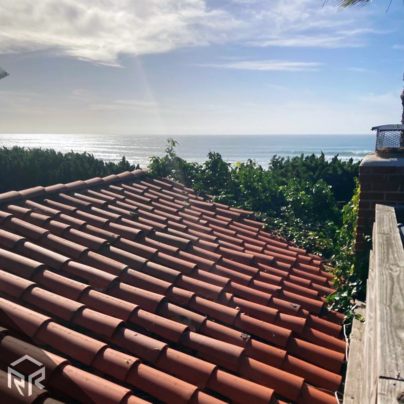 A photo of a tile roof overlooking the ocean.