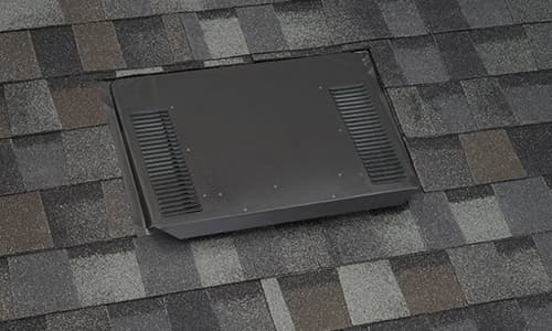 A black low-profile metal exhaust vent installed on an asphalt shingle roof in San Diego.
