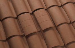 An O'Hagin tile roof vent color-matched and blended almost invisibly into a terracotta barrel-tile roof.